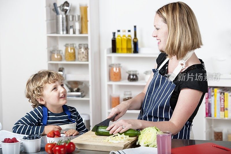 快乐的白人母亲和儿子准备健康的一餐