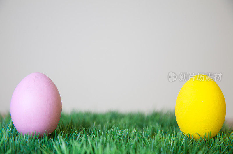 草地上有粉红色和黄色的复活节彩蛋