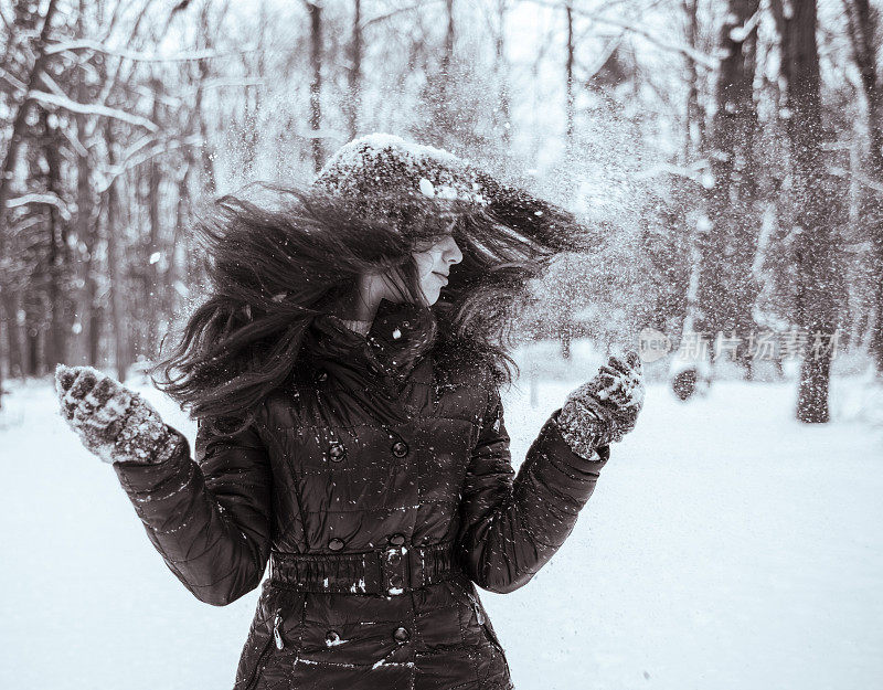 十几岁的长发女孩玩雪