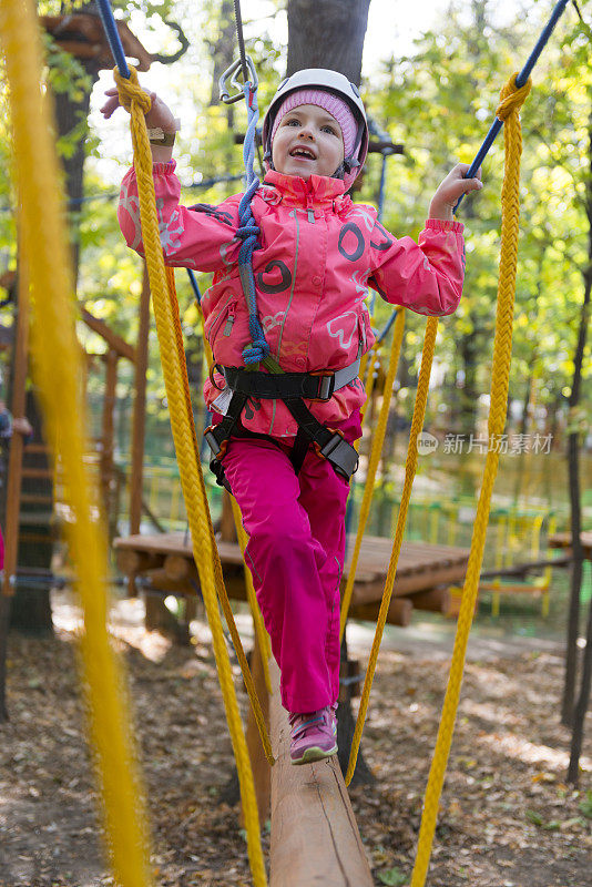 十几岁的女孩有乐趣在绳索课程冒险公园。Zipline为孩子。