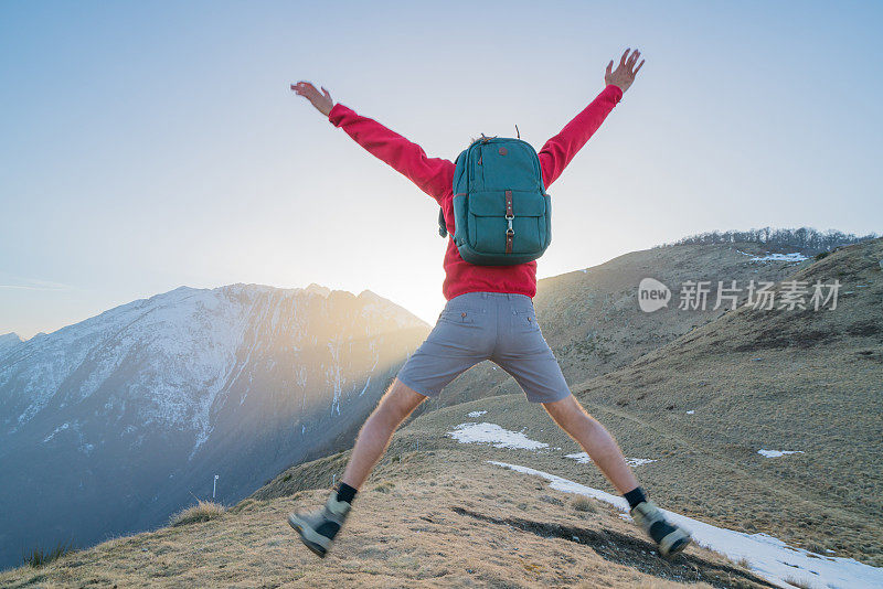 欢快的年轻人在空中跳跃，山野风光