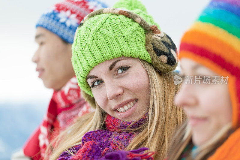 微笑年轻女子的肖像在冬天的衣服与朋友