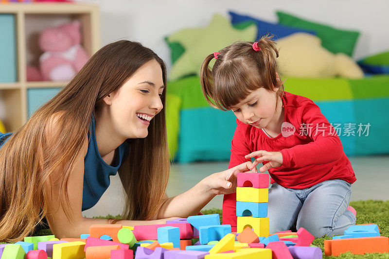 母亲和女儿玩建筑玩具