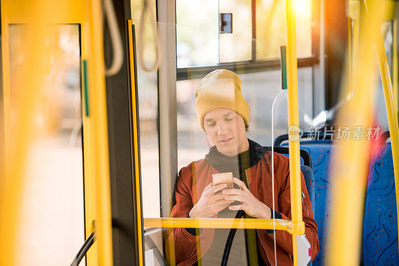 一名男子在公交车上使用智能手机