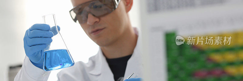 一个男化学家拿着一个玻璃试管