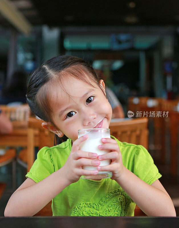 早上在餐厅给你一杯牛奶的亚洲女孩。盯着她的脸。