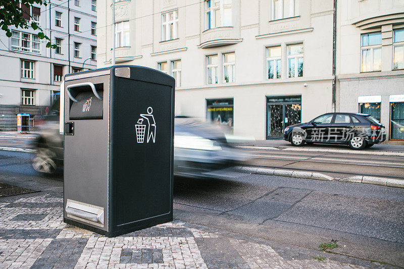 捷克共和国布拉格街头的一个现代智能垃圾桶。在欧洲收集废物，以便日后处理。环保的垃圾收集。在背景中，汽车正在行驶。