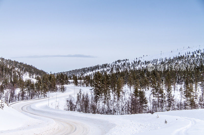 典型的芬兰景观和冰雪覆盖的冬季道路