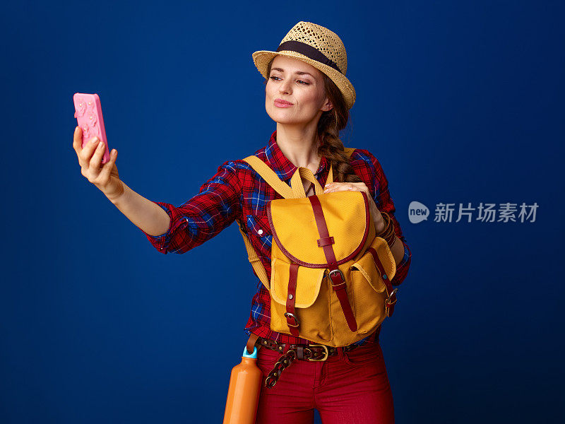 年轻的女旅行者正在用智能手机自拍