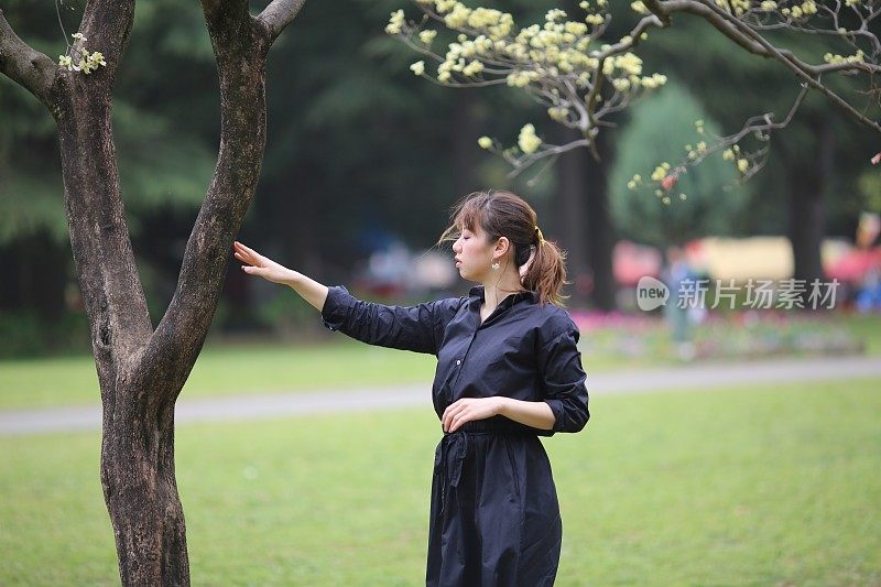 年轻女子欣赏春天的花朵