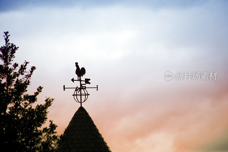 公鸡形状的风向标，夕阳背景。