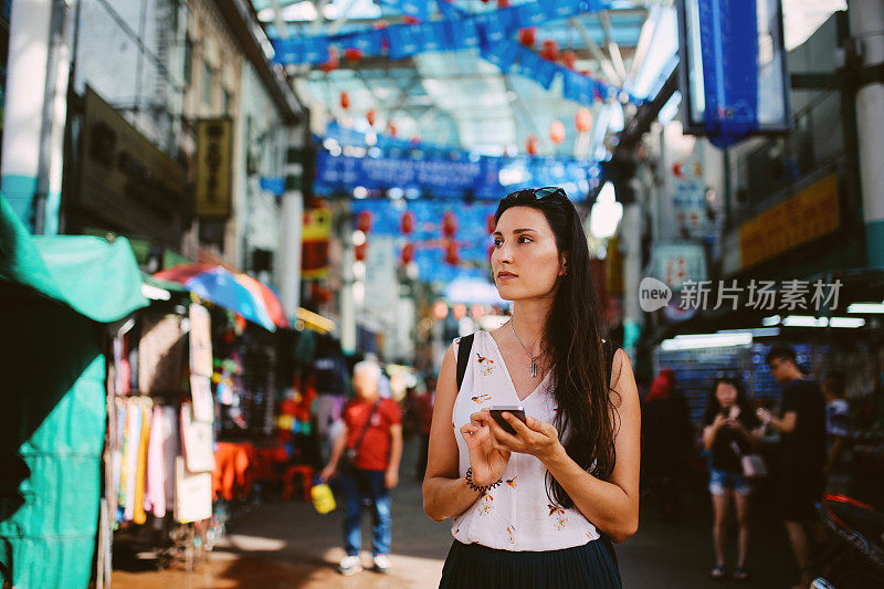 年轻的旅行者女人走在吉隆坡唐人街区