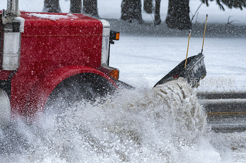 扫雪机在自卸车上清理县道积雪的特写