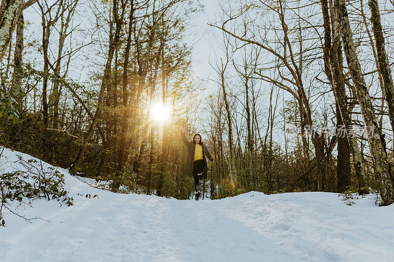 女人在雪地上蹦蹦跳跳