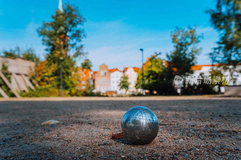 在公园里玩皮球游戏的金属与老lübeck城市建筑在模糊的背景。德国