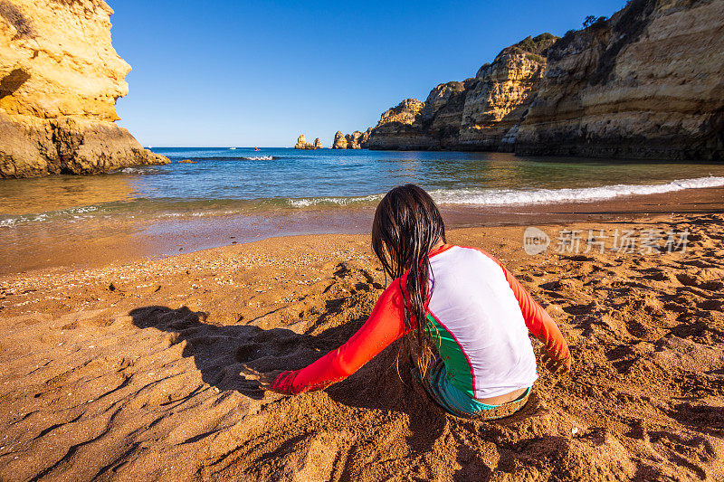 小女孩在葡萄牙阿尔加维普拉亚多纳阿纳海滩的沙滩上玩耍