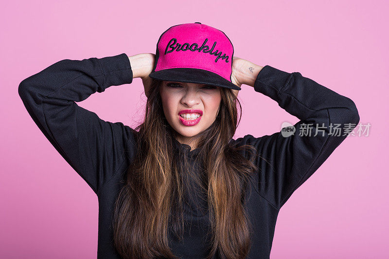 愤怒的年轻亚洲妇女在兜帽衬衫和帽子