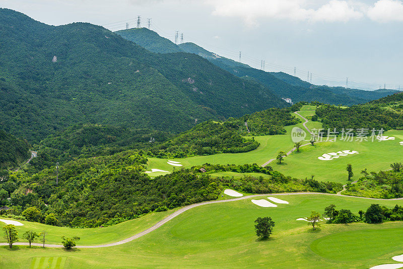 深圳华侨城东部(华侨城东部)的一个绿色的高尔夫球场，在山谷和山区背景。有三个主题公园:骑士谷、茶溪和风谷。