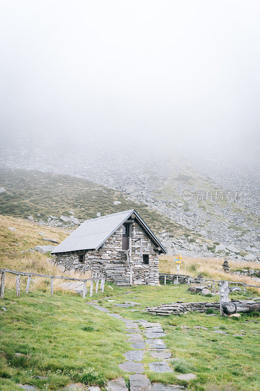 山上草地上的石屋，雾气蒙蒙