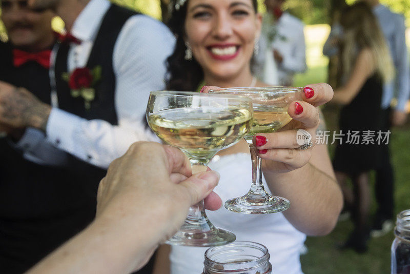 新婚的新娘在户外的婚宴上祝酒