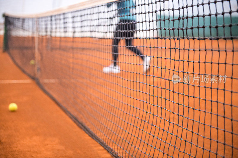 高级女子打网球透过网的视图近距离