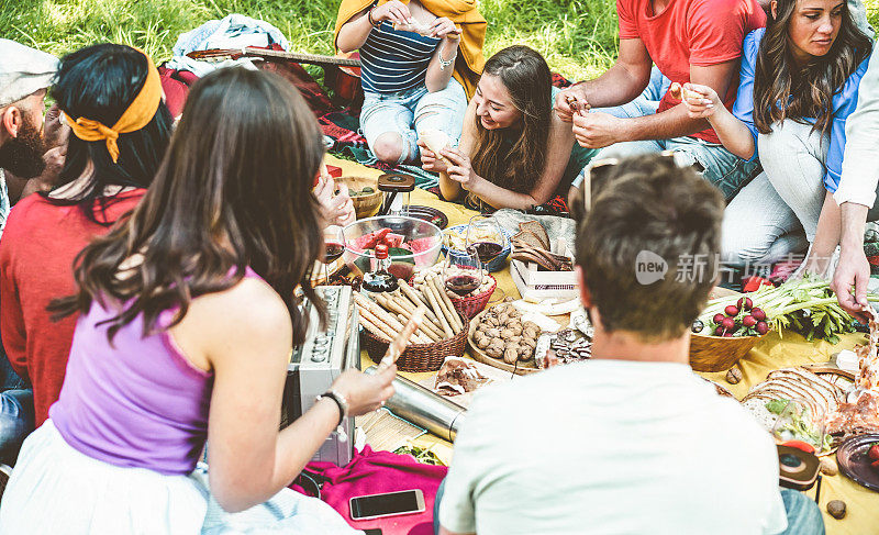 快乐的朋友吃和喝葡萄酒在户外野餐-年轻时尚的人们在自然中享受美食和一起欢笑-主要集中在女孩中心女孩与金发
