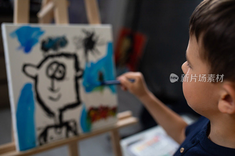 一个男孩在画架上画肖像