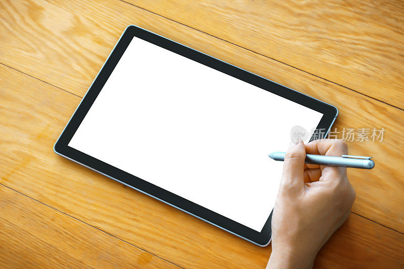 一个女人的手拿着一支笔指着平板电脑的屏幕