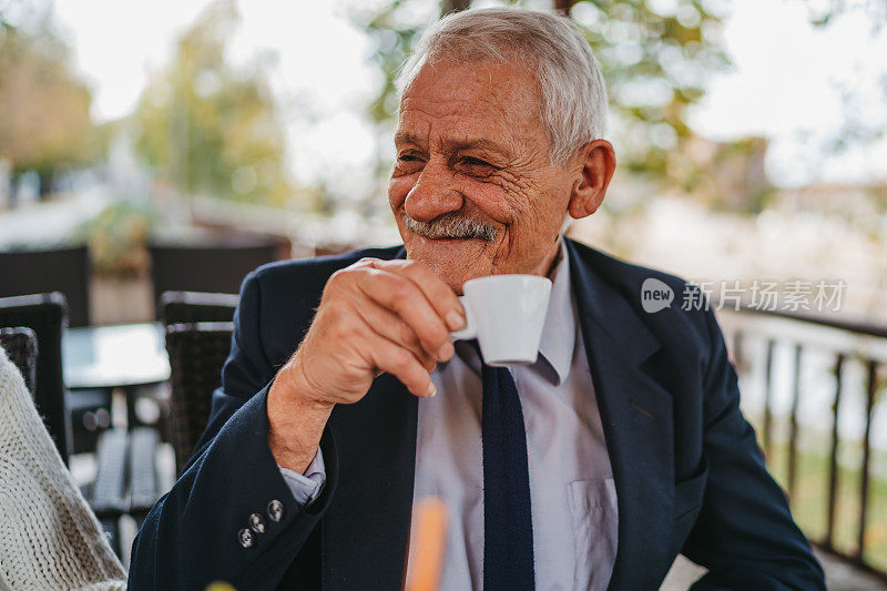 一位老人在路边咖啡馆喝咖啡