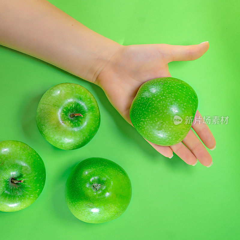 水果绿苹果在彩色的背景手汁美味