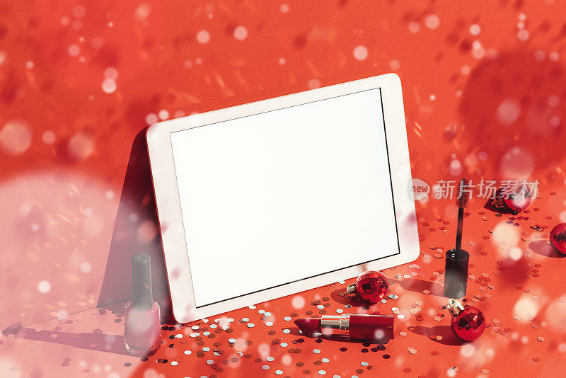 数字平板模型，模板和化妆品在红色背景与五彩纸屑雨