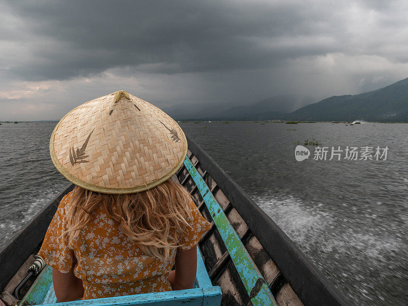 在缅甸茵莱湖上乘坐长尾船的妇女