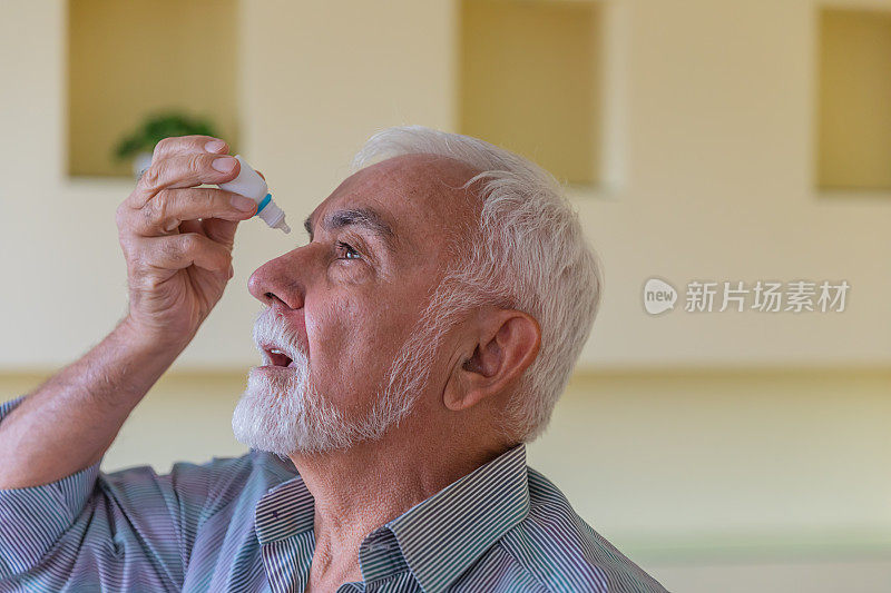 患有白内障或结膜炎的老年人正在家中使用滴眼液。