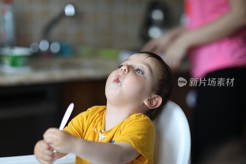 小男孩在他的高椅子上吃饭