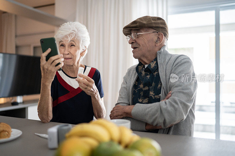 一对老年夫妇在家里用手机进行视频通话