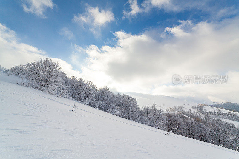 美丽的喀尔巴阡山脉。从高处俯瞰积雪覆盖的山峰。美丽的天空覆盖着冬天的雪山。乌克兰