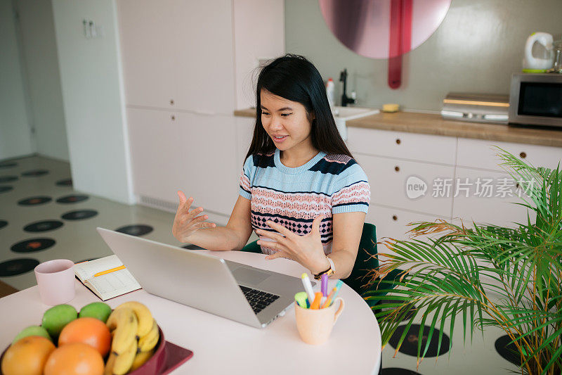 由于冠状病毒封锁，快乐的年轻东亚女性在家工作