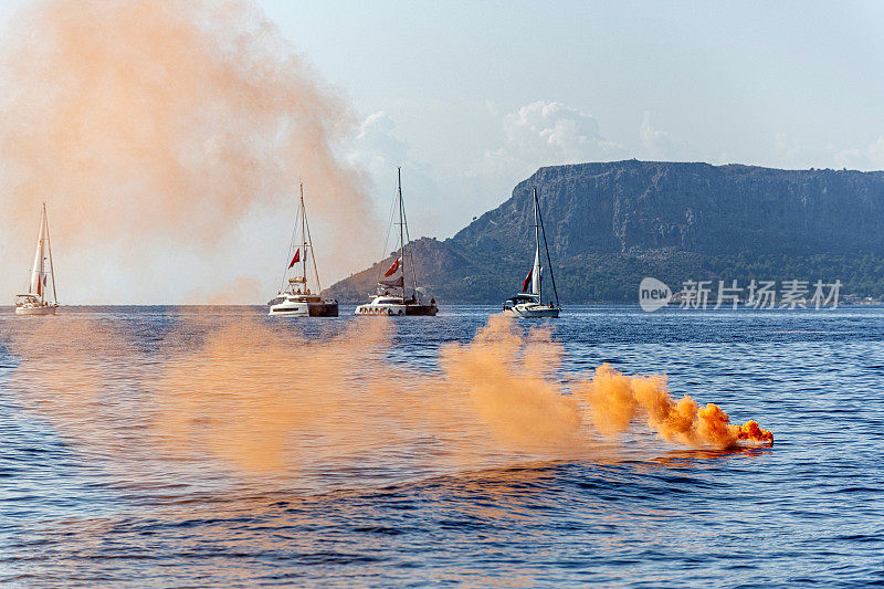 橙色烟雾弹和帆船。遇险信号