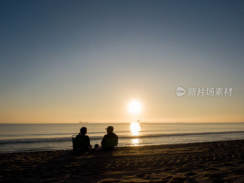 一对夫妇的剪影在佛罗里达海滩日出