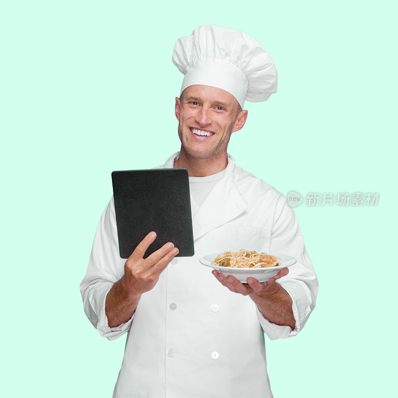 白人男厨师在有色背景下穿着制服，使用数码平板电脑