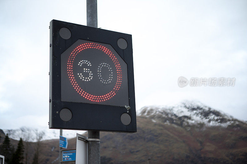 发光的路标指示时速30英里，远处是雪山