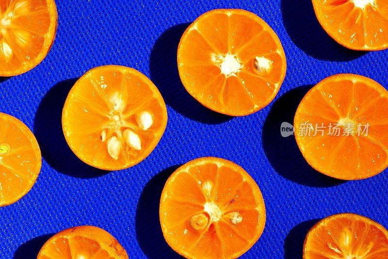 封闭新鲜的金橘水果-蓝色背景。