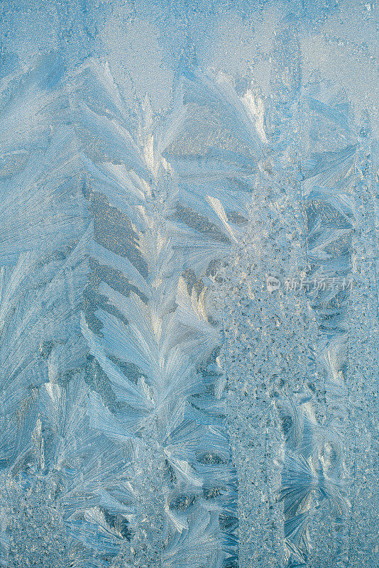 一个绝妙的冰饰在霜窗在浅蓝色的方案