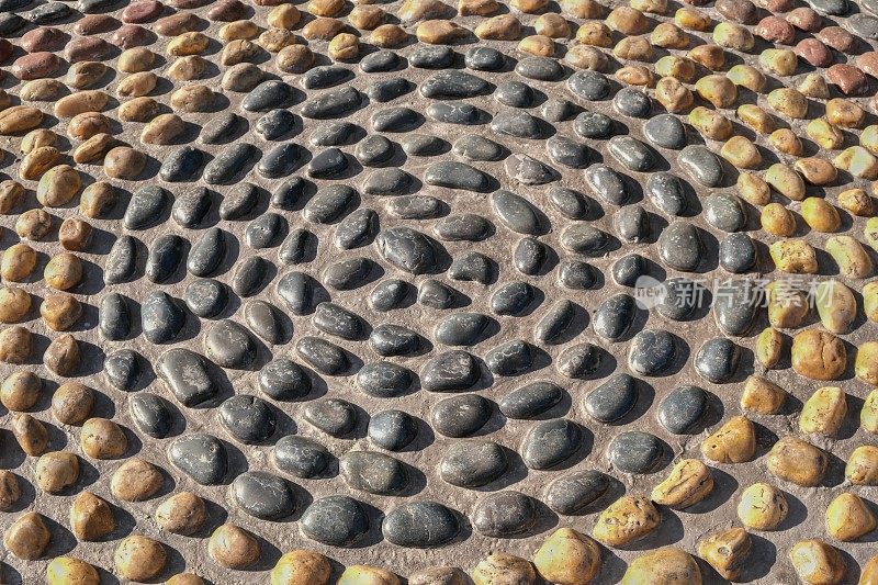 马赛克圆形图案由凸面圆形卵石石块组成。地面路径纹理表面卵石。反射石圈是将鹅卵石按圆形排列的设计