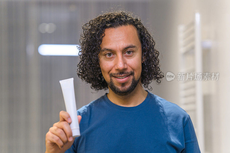 中年西班牙裔男子拿着牙膏管