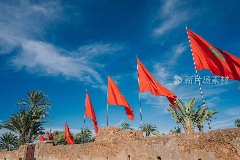 摩洛哥国旗与蓝色的天空上的老城城堡建筑