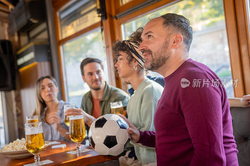 人们在酒吧里观看足球比赛欢呼