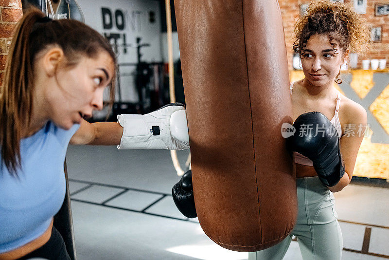 年轻的运动女性在健身房打拳击