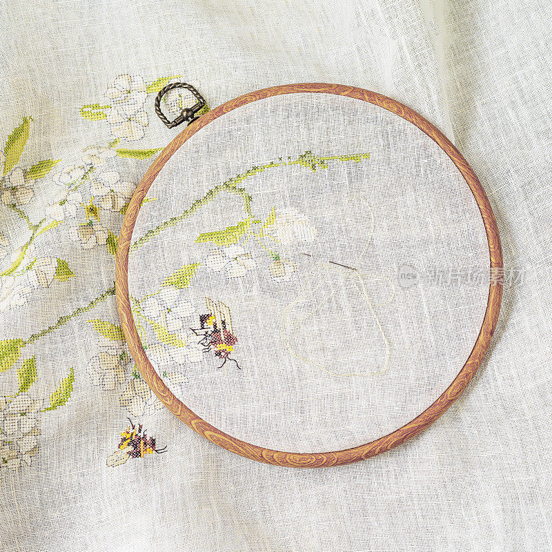 木刺绣环顶视图，针与线和织物与花卉图案。爱好和针线活观念
