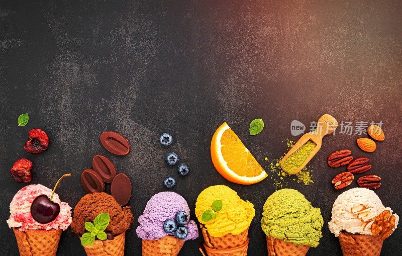 各种口味的冰淇淋在蓝莓，绿茶，开心果，杏仁，橘子和樱桃设置在深色的石头背景。夏日和甜蜜的菜单概念。